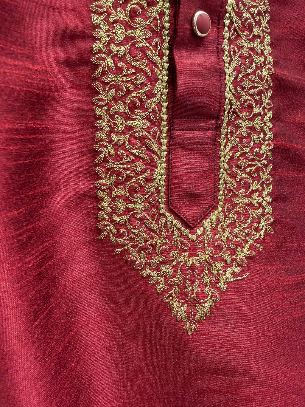 Close-up of the gold floral thread embroidery around the kurta placket