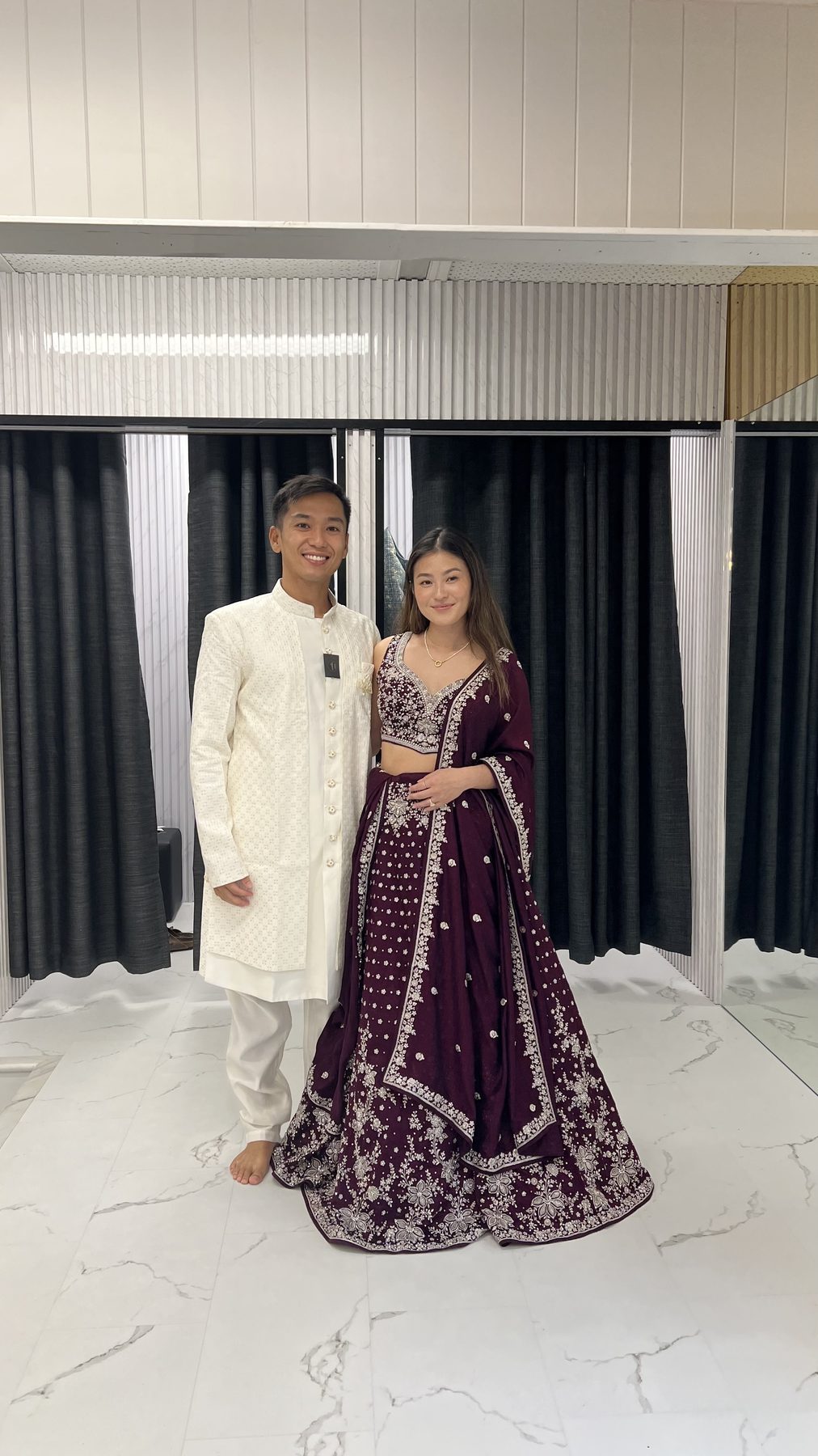 Couple in a purple lehenga and ivory sherwani