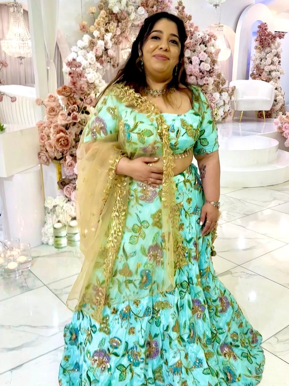 Customer in a teal lehenga with a gold dupatta
